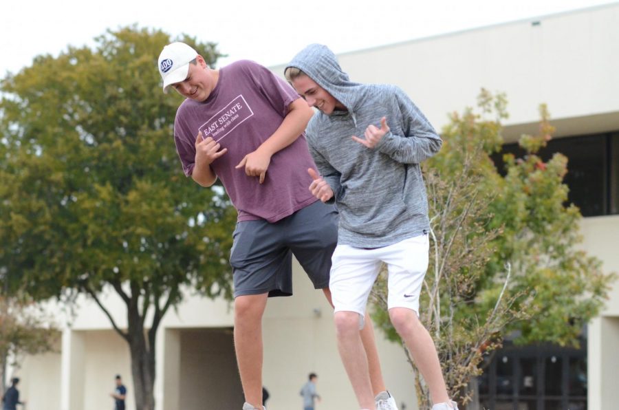 Seniors Hunter Pierson and Austin King dance while DJ plays music. 