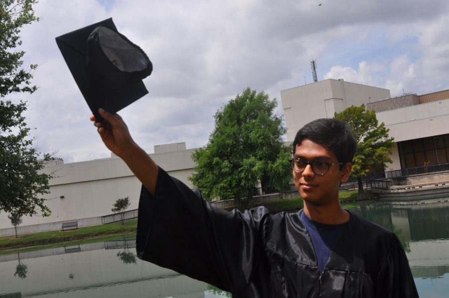 Senior Mohit Gupta celebrates his title of salutatorian by the school pond with a graduation cap and gown.