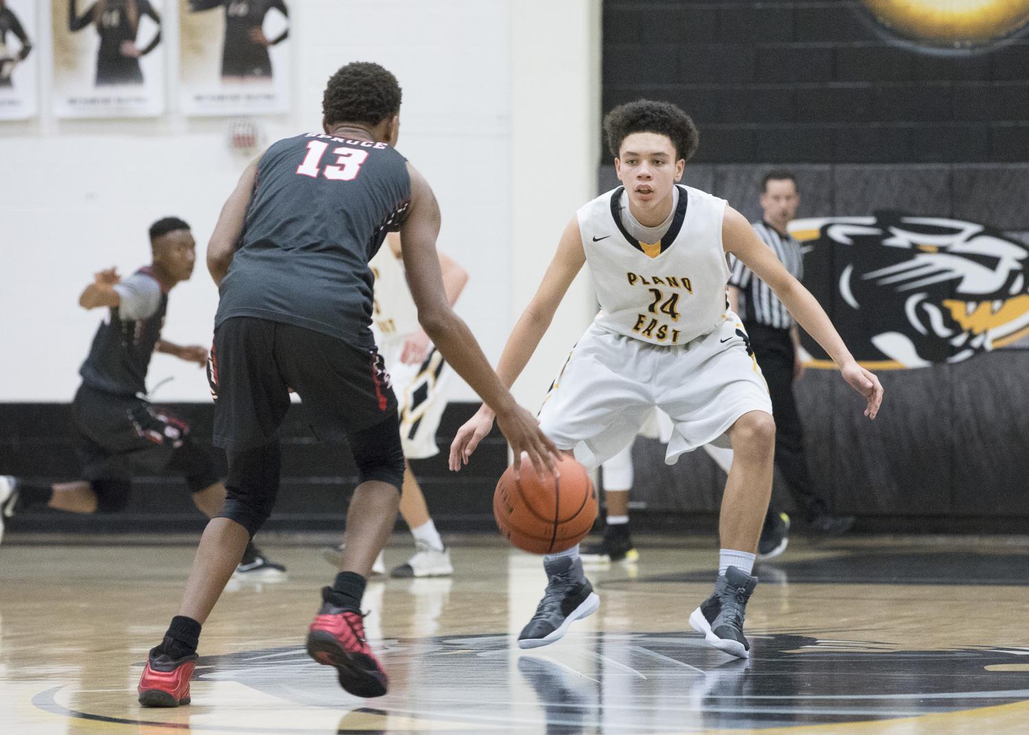 Freshman Connor Johnson defends Spruce point guard at the top of the key on Feb. 8.