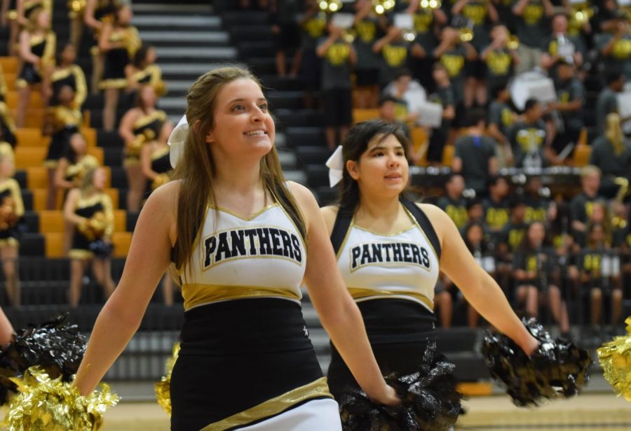 Senior Brooke Craghead and junior Vivian Easley cheer during the band performance at the Camp Panther pep rally on Aug. 3.