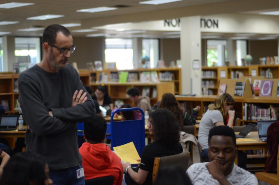 Librarian Steven Lewis works with senior Kemka Anamekwe in conducting research on April 23. 