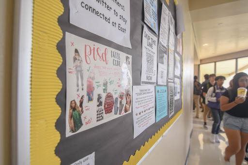 Informative Posters: Students walk past a dress code poster on Sept. 13 in the hallway. The fashion design class created these posters from magazine cut-outs to advise others about the dress code policy. “I think the meaning was to set guidelines of how to express yourself through clothes/fashion appropriately while at school,” junior Kayla Queneau said. 

Photo Credit: Emily Ojeda
