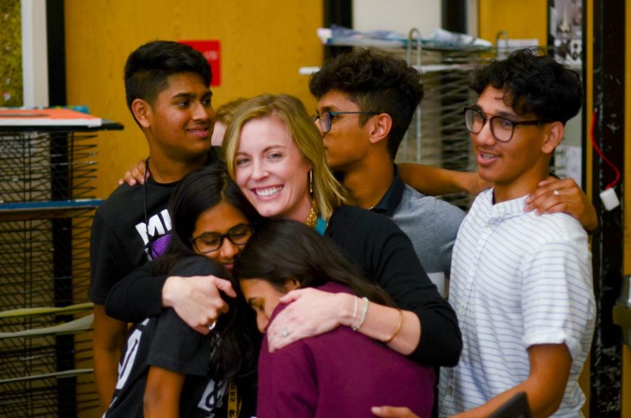 Weide wraps students in a group hug after her surprise party. Senior IB HL art student Ismaeel Khan planned the event for Weide’s last day during her fifth period class, bringing cake and pizza for everyone to enjoy. “Ms. Weide has done so much for us,” Khan said. “This is the least we could do to repay her for all of her efforts.” 
