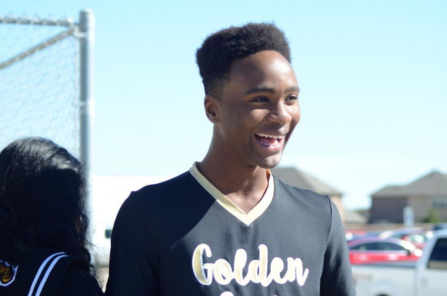 Golden Girls, Golden Smiles: Junior Charles Igbo laughs at something another drill team manager says Friday, Nov. 1. The managers gathered at the beginning of practice on the band pad to prepare for the football game against Plano West later that night. “Usually I ride with band to the games, but before halftime I go with [the Golden Girls] and I stand on the sidelines and do whatever I [need] to,” Igbo said. “It’s always exciting.”
