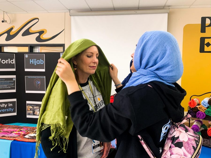 Freshman Mehreen Syed helps assistant special education teacher Misti Stolp wear a headscarf. Syed was one of many students volunteering at the World Hijab Day table. “The hijab is a beautiful symbol of freedom and diversity,” Syed said. “World Hijab Day celebrates empowerment and unity, and as a high school Muslim student, I loved being a part of it.”