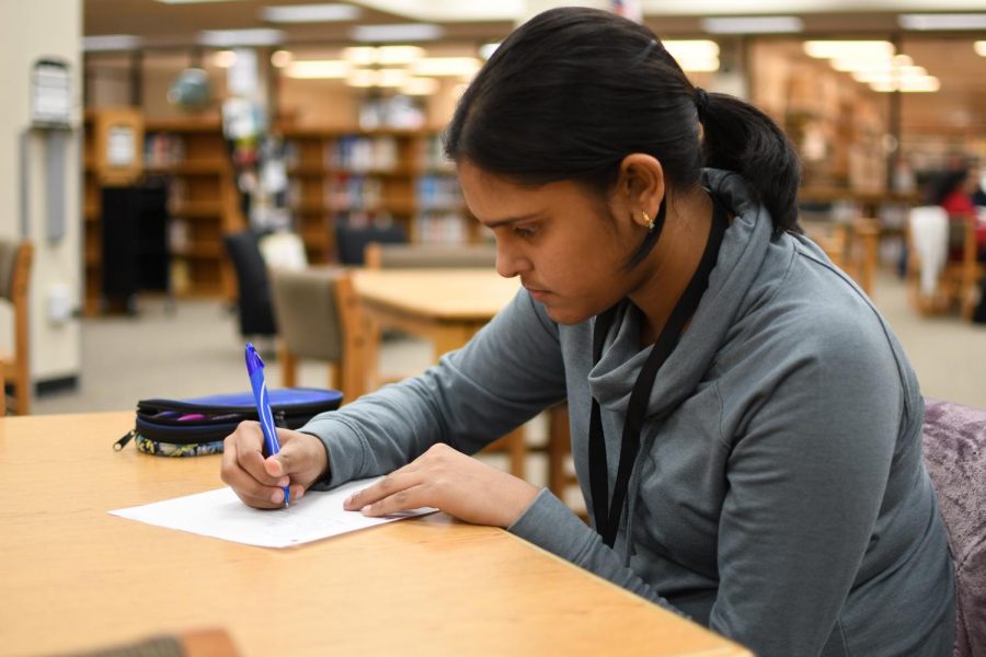 Freshman+Maryam+Ahmed+writes+a+poem+in+the+library+during+lunch+Nov.+14.