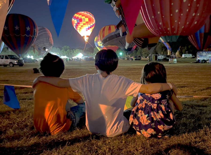 Children watch a hot air balloon set in the distance at the Plano Balloon Festival on Sep. 24