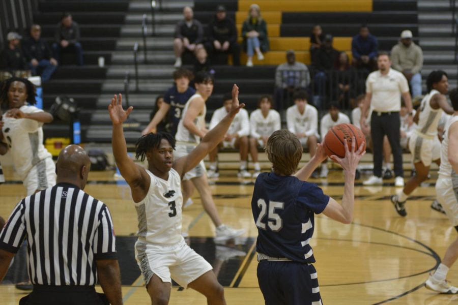 Junior Isaiah Brewington attempts to block the ball from the opposing team at the varsity game versus Flower Mound on Jan. 20.