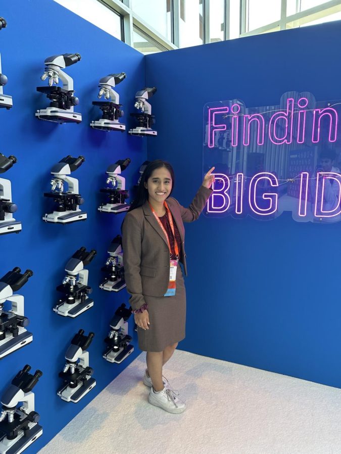 Senior Shriya Bhat points at finding big ideas sign at the International Science and Engineering fair in Dallas on May 18.
