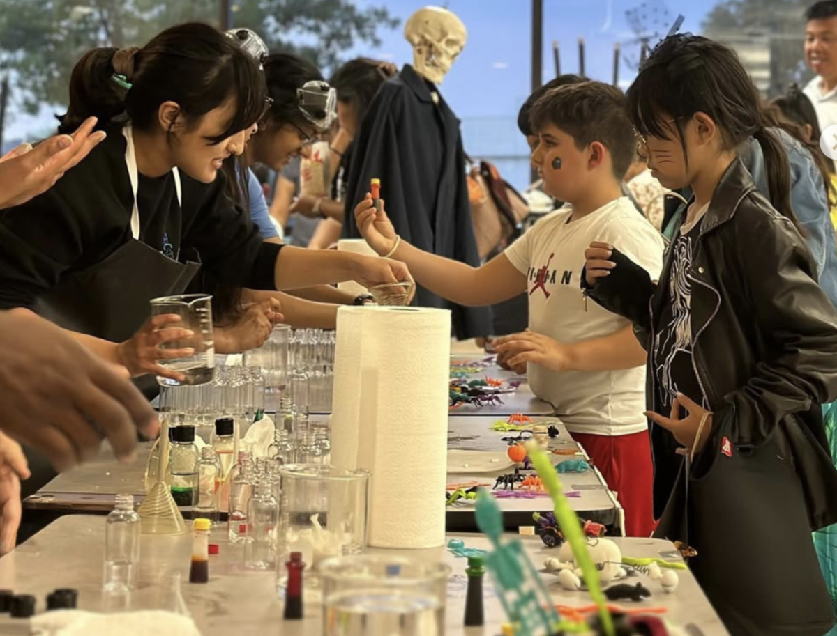 LASER club members volunteering making slime for kids during "Paloween" event.